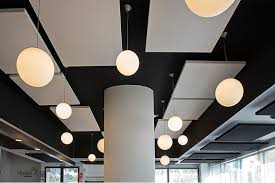 Techos con paneles acústicos y lámparas esféricas en un entorno moderno.